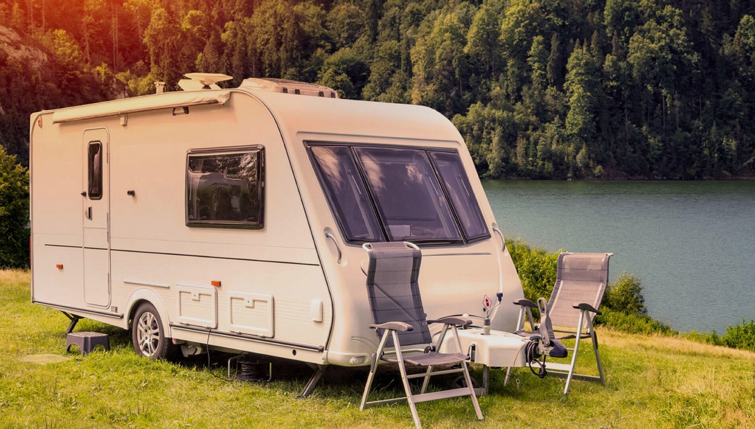 Caravan next to lake with deck chair