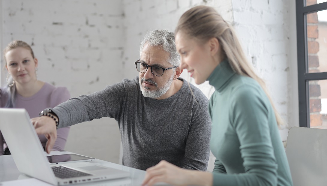 Older man and younger woman looking at laptop