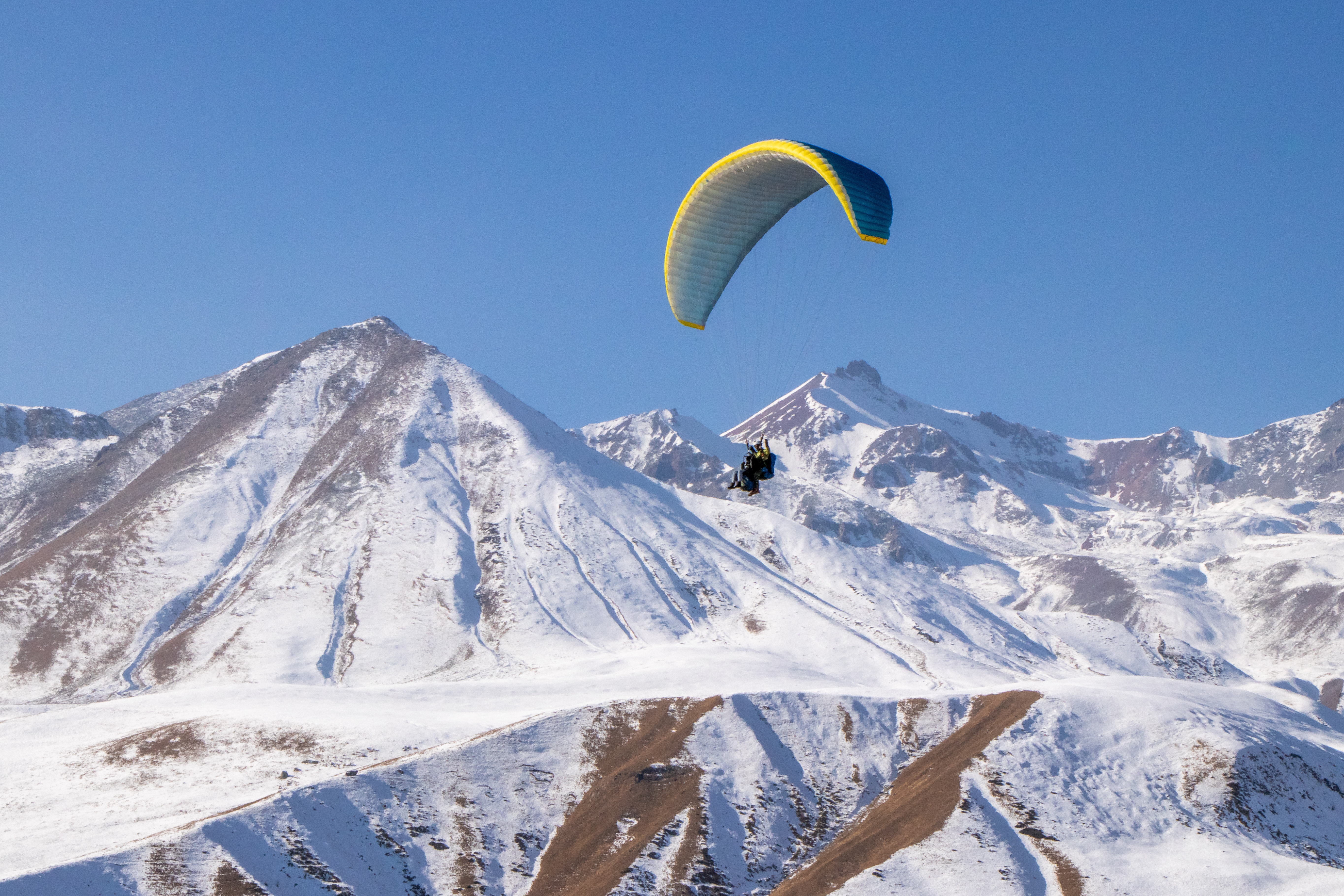 extreme sports parachuters with snowy mountains
