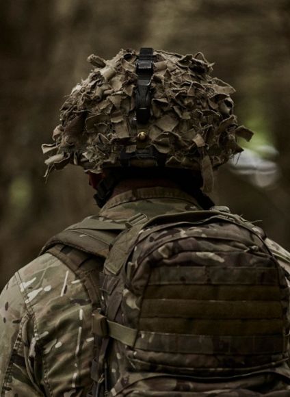 Man protected by Army Insurance walks in wooded area.