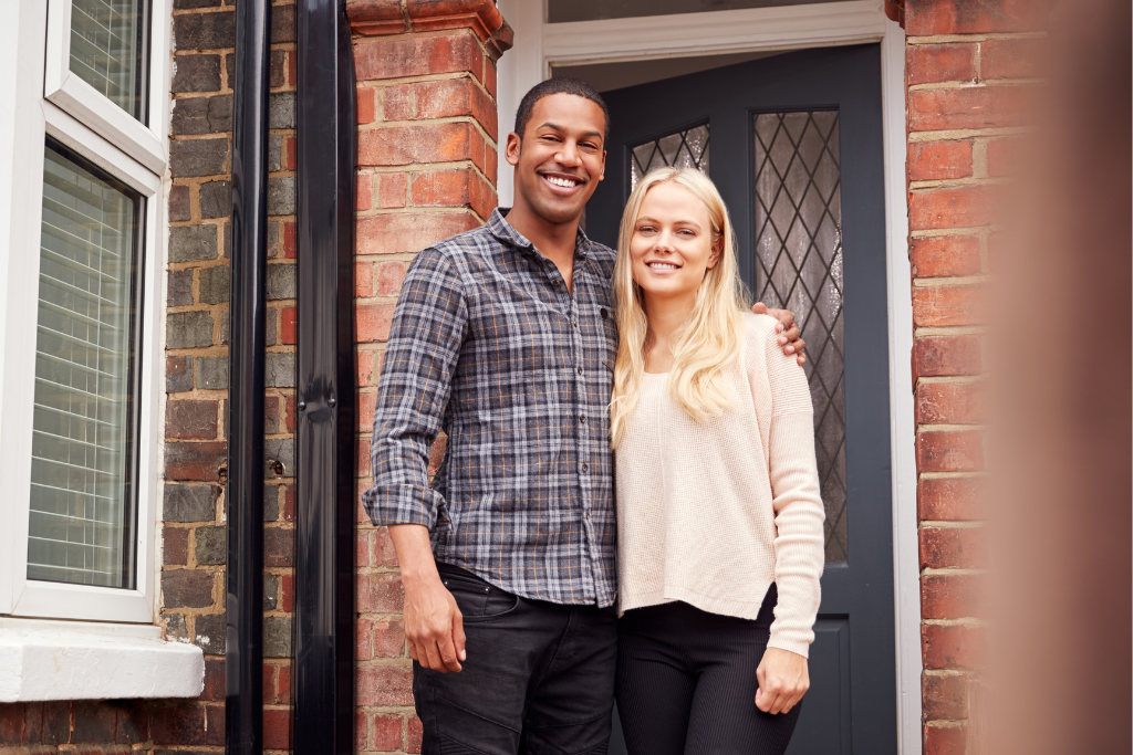 Military veteran stands outside a new property with his partner. The man looks relaxed due to the property being protected by his Buildings & Contents Insurance policy.